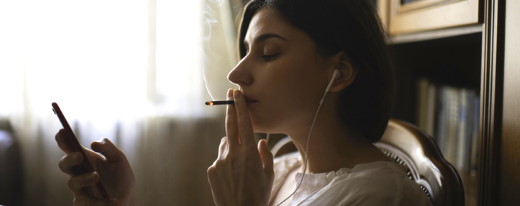 Frau mit Smarphone raucht