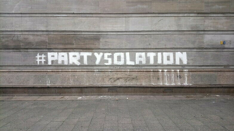 Hauswand mit aufgemaltem Schriftzug "#Partysolation"