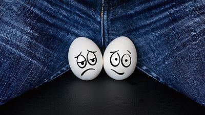 Zwei mit sorgenvollen Gesichtern bemalten weißen Eier im Schritt