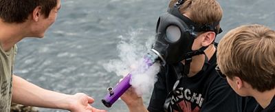 Jugendlicher raucht Bong mit Gasmaske