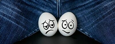 Zwei mit sorgenvollen Gesichtern bemalten Eier im Schritt