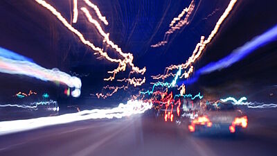 Langzeitbelichtung und verschwommene Sicht auf nächtliche Straße mit Autos von hinten