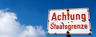 Schild mit Aufschrift "Achtung Staatsgrenze"