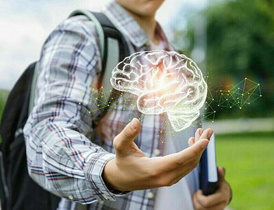 Schüler/Student hält die Hand auf, darüber schwebt ein computergezeichnetes Gehirn