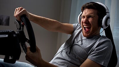 Junger Mann lenkt angestrengt in einem Fahrsimulator