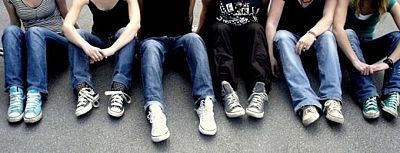 Sechs auf dem Boden sitzende Jugendliche. Man sieht nur Oberkörper und Beine.