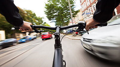 Fahrradfahrer aus der Ego-Perspektive mit Lenker im Blick