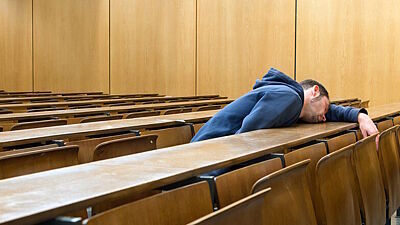 Student schläft im leeren Hörsaal
