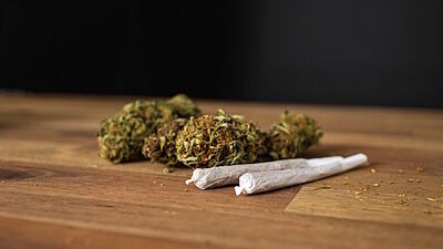 Zwei Joints und Marihuana auf einem Holztisch