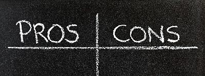 Mit Kreide steht in tabellarischer Form auf einer Tafel geschrieben "Pros - Cons" 