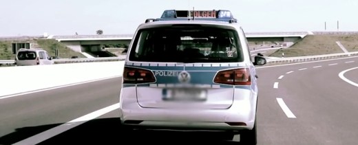 Vorausfahrendes Polizeitauto mit Laufschrift 