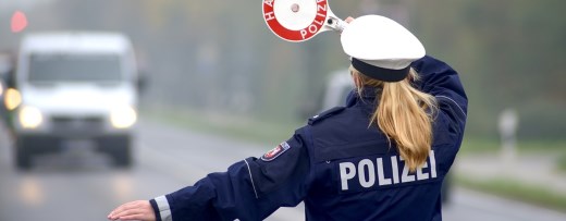 Polizistin winkt Auto mit Kelle raus