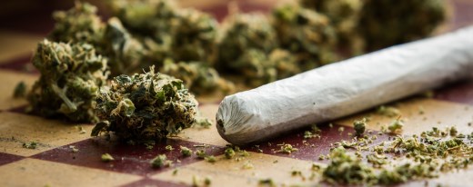 Marihuana und ein fertig gedrehter Joint auf einem Schachbrett