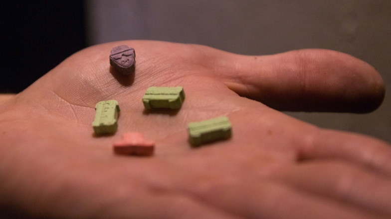 Auf einer Hand liegen fünf Ecstasypillen in verschiedenen Farben