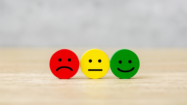 Ein roter trauriger, ein gelber neutraler und ein grüner glücklicher Smiley nebeneinander aufgereiht