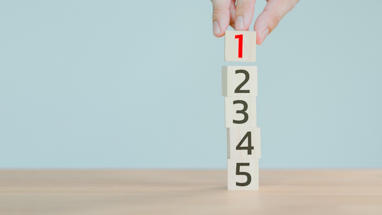 Hand bildet Turm aus Würfeln von 1 bis 5
