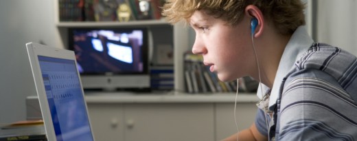 Jugendlicher sitzt konzentriert vor einem Laptop