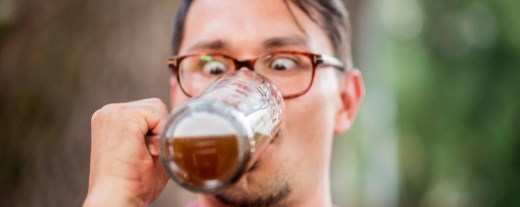 Mann trinkt Bier und schaut ins Glas