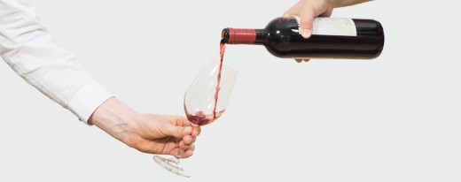 Ein Glas Rotwein wird eingeschenkt