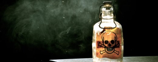 Flasche mit Totenkopfsymbol vor schwarzem Hintergrund