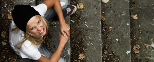 Junge Frau sitzt auf einer Treppe und schaut wütend nach oben