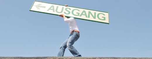 Mann trägt großes Schild mit Aufschrift "Ausgang" auf der Schulter