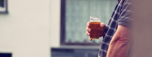 Mann hält Bierglas in der Hand