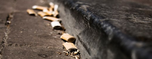 Ausgedrückte Zigarettenkippen am Straßenrand