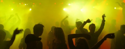 Tanzende Menschen im künstlichen Nebel eines Techno-Clubs
