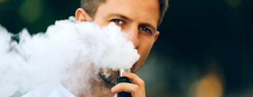 Mann konsumiert E-Zigarette, Dampf steigt auf